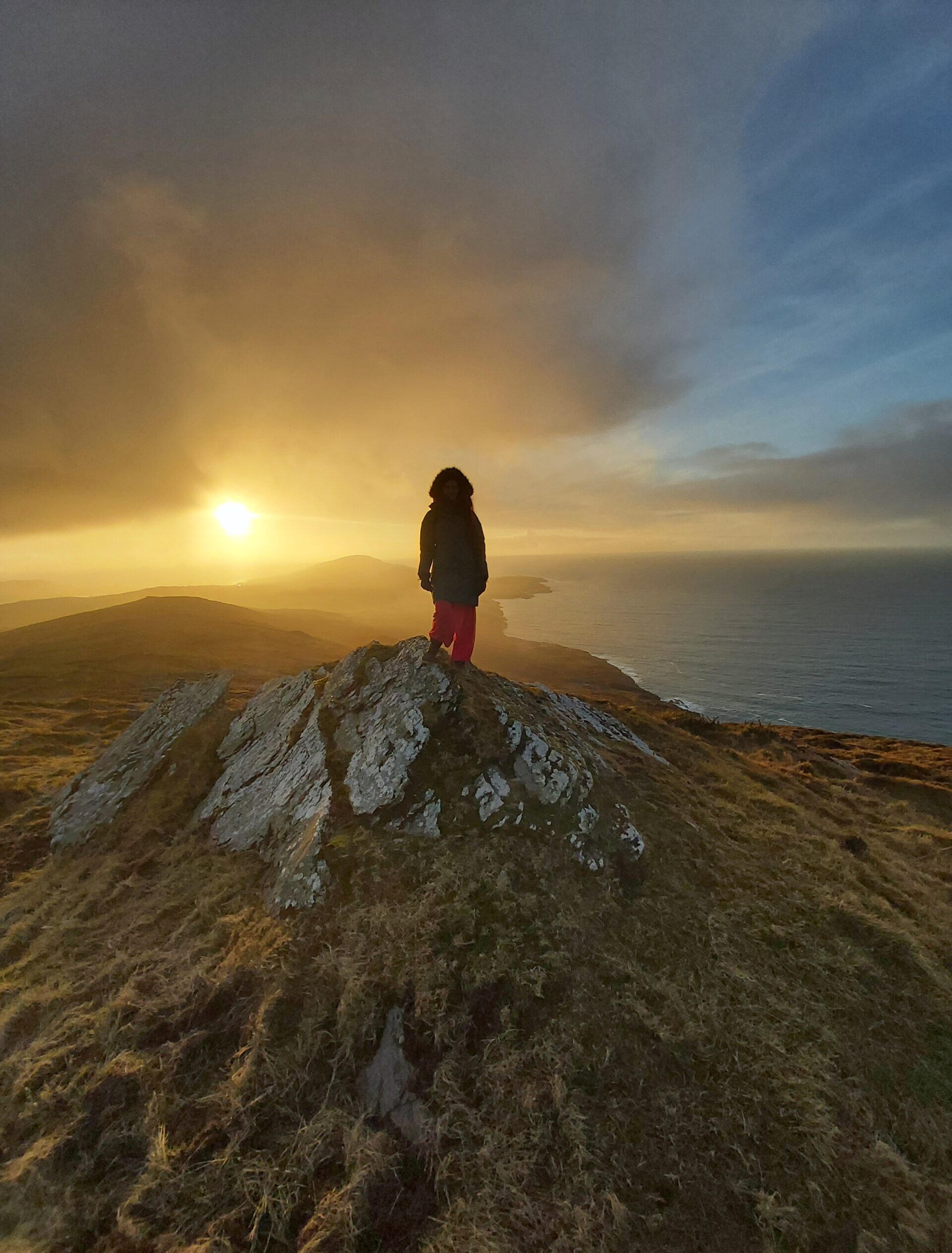 A solitary woman walking atop an Irish mountain, seeking answers to the question of how can I change myself